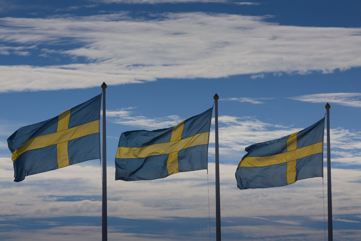 Drei schwedische Flaggen am blauen Himmel